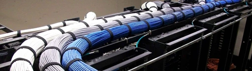 Bundled and dressed cat6 cables running on cable trays on top of server racks in server room.